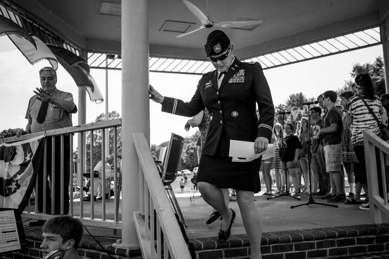 Lt. Col. Alicia Masson in dark shades and military uniform descending from a stage in Bisset Park in Virginia