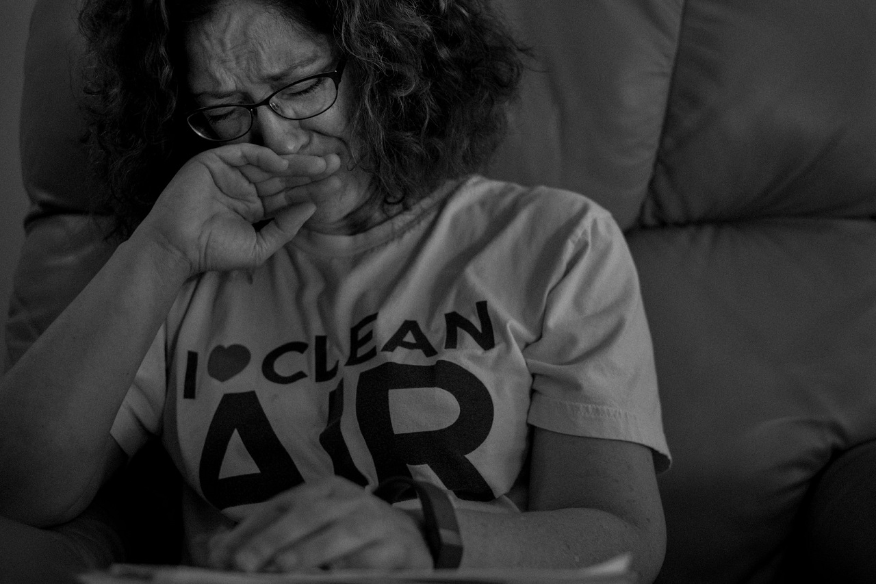 A crying Devawn Bledsoe in eyeglasses and T-shirt that says ‘I Love Clean Air’ with ‘love’ as a heart symbol